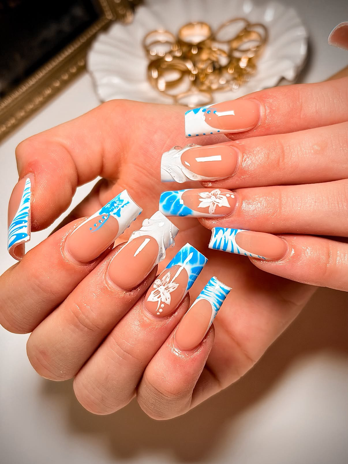 Medium blue and white marble Gel-X set with tropical floral accents